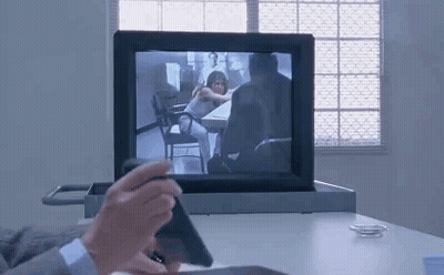 Man Sitting At Desk Holding Phone In Front Of Computer GIF