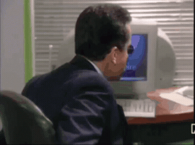 Man Sitting At Desk Looking At Microsoft Computer Screen GIF