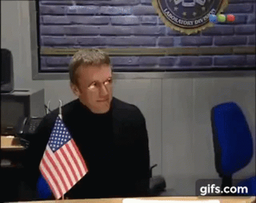Man Sitting At Desk With American Flag GIF