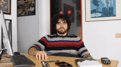 Man Sitting At Desk With Computer And Book GIF