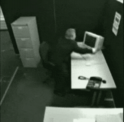 Man Sitting At Desk With Computer And Phone GIF