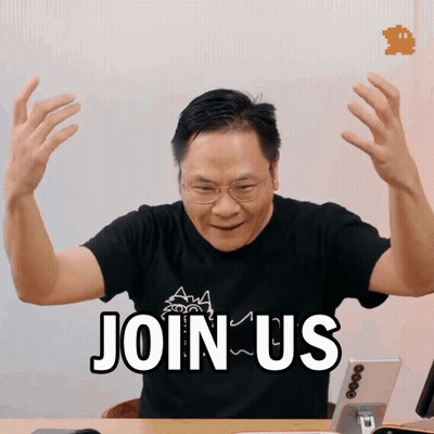 Man Sitting At Desk With Hands Up Saying Join Us GIF