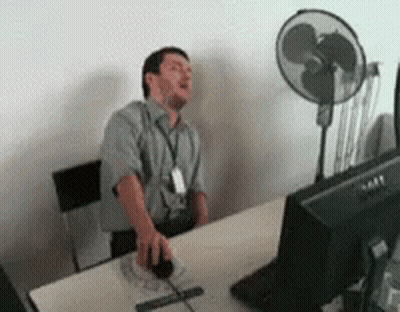 Man Sitting At Desk With Mouse And Fan GIF