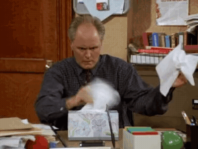 Man Sitting At Desk With Tissues GIF