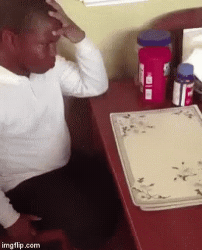 Man Sitting At Desk With Tylenol Bottle GIF