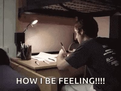 Man Sitting At Desk Writing In Dorm Room GIF