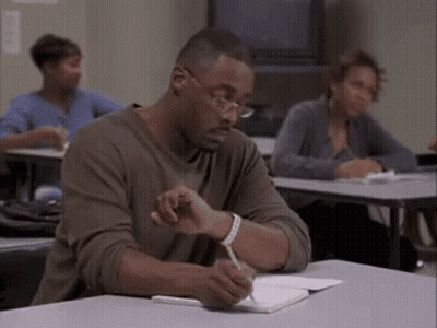 Man Sitting At Desk Writing In Notebook GIF
