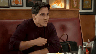 Man Sitting at Diner Table With Plate of Food