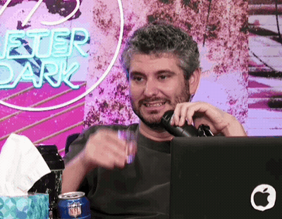 Man Sitting At Microphone In Front Of Chester Dark Sign GIF