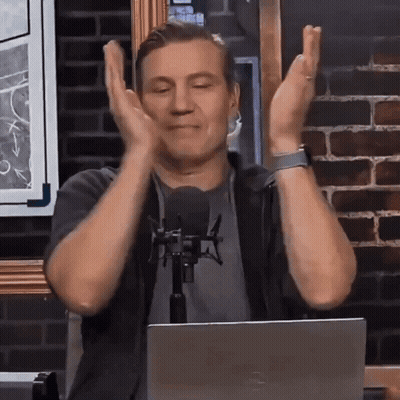 Man Sitting At Microphone With Hands In Air GIF