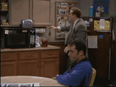 Man Sitting At Refrigerator With Sign Saying Less GIF