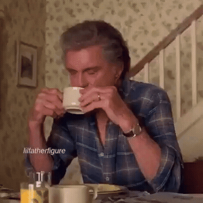 Man Sitting At Table Drinking From Cup GIF