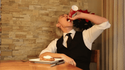 Man Sitting At Table Drinking From Cup GIF