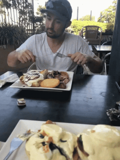 Man Sitting At Table Eating Food GIF