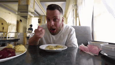 Man Sitting At Table Eating With Spoon GIF