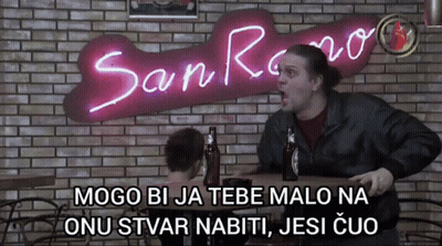 Man Sitting At Table In Front Of San Reno Sign GIF