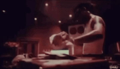 Man Sitting At Table Playing Music In Dark Room GIF