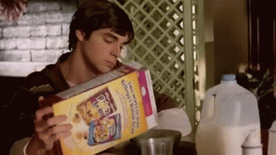 Man Sitting At Table Reading Cereal Box Drinking Milk GIF