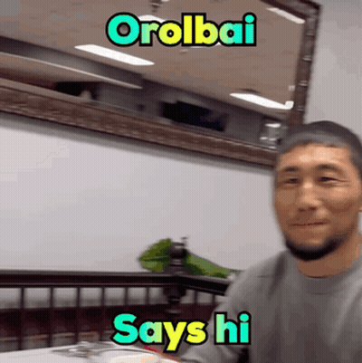 Man Sitting At Table Saying Hi GIF