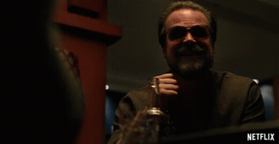 Man Sitting At Table With Alcohol And Netflix Logo GIF