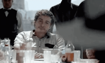 Man Sitting At Table With Alcohol Bottles And Glasses GIF