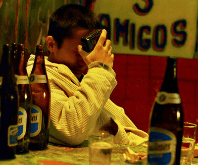 Man Sitting At Table With Beer And Amigos Sign GIF