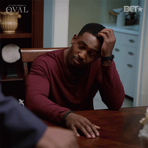 Man Sitting At Table With Bet Logo GIF