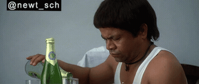 Man Sitting At Table With Champagne And Sign Saying @Newt_sch GIF