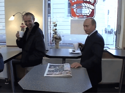 Man Sitting At Table With Frankfurt Newspaper GIF