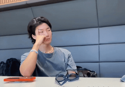 Man Sitting At Table With Hand On Face GIF