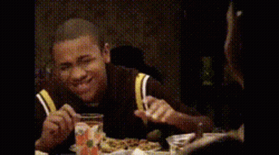 Man Sitting At Table With Hands In Air GIF