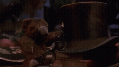 Man Sitting At Table With Lamp And Stuffed Animal GIF