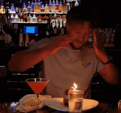 Man Sitting at Table With Martini and Candle