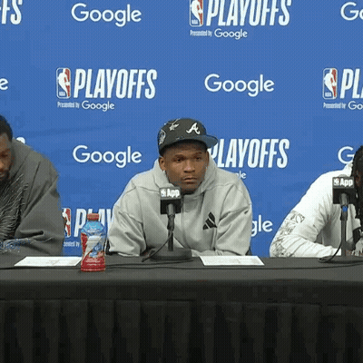 Man Sitting At Table With Microphones GIF