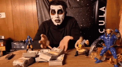 Man Sitting At Table With Money And Toys GIF
