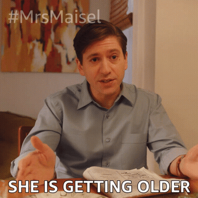 Man Sitting At Table With Newspaper Saying She Is Getting Older GIF