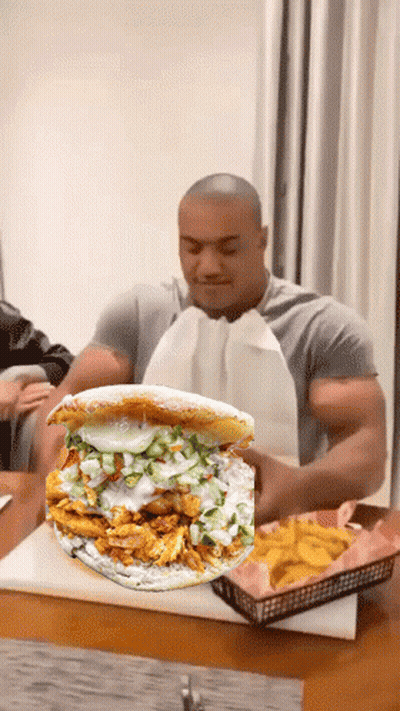 Man Sitting At Table With Sandwich And French Fries GIF