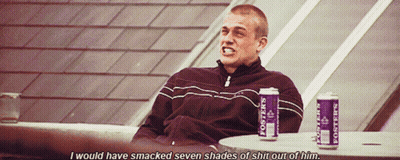 Man Sitting At Table With Two Cans Of Posters GIF