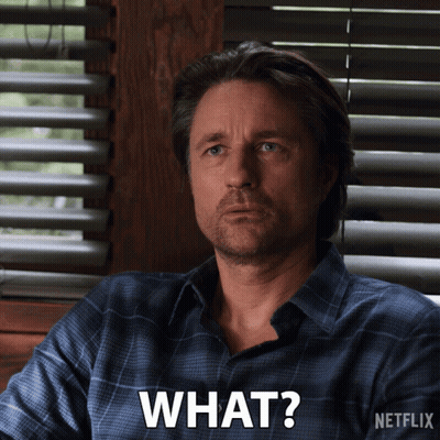 Man Sitting By Window With Blinds Saying What GIF