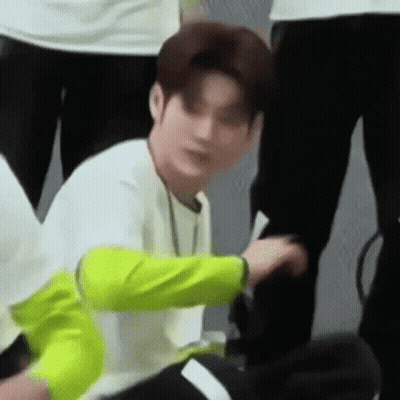 Man Sitting Cross-Legged In White Shirt And Neon Jacket GIF