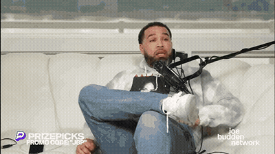 Man Sitting Crossed Legs In Front Of Microphone GIF