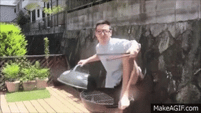 Man Sitting Crossed Legs On Grill With Wooden Stick GIF