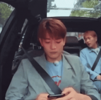 Man Sitting In Back Seat Looking At Phone GIF
