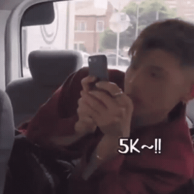 Man Sitting In Car Looking At Phone 5K GIF