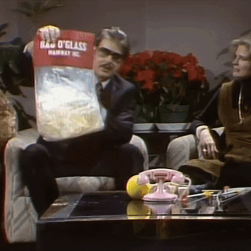 Man Sitting In Chair Holding Bag O Glass GIF