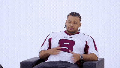 Man Sitting In Chair Holding Sign Saying Fanum GIF