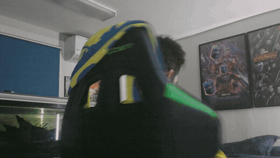 Man Sitting In Chair In Front Of Avengers Poster GIF