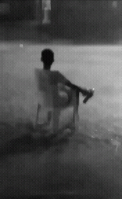 Man Sitting In Chair In Rain Holding Bottle GIF
