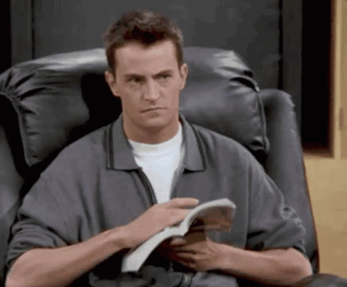 Man Sitting In Chair Reading Magazine GIF