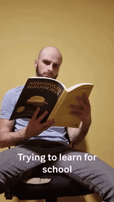 Man Sitting In Chair Reading Trying To Learn For School GIF